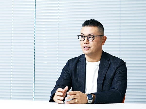 ブラインドを背に語る代表取締役社長 髙木 秀悟